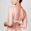Back view of curve model wearing a blush pink Liberté Bowery Lace Demi Bra with scalloped edges on the band