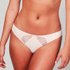 Model wearing a Liberté Crosby Scalloped Cheeky in blush pink, featuring Crosby performance micro jersey and lace insets.