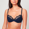 Model wearing a midnight blue Liberté Crosby Plunge Bra with Crosby performance micro jersey on the bottom cup and lace with scalloped edges on the top cup.