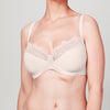 Model wearing a blush pink Liberté Crosby Plunge Bra with Crosby performance micro jersey on the bottom cup and lace with scalloped edges on the top cup.