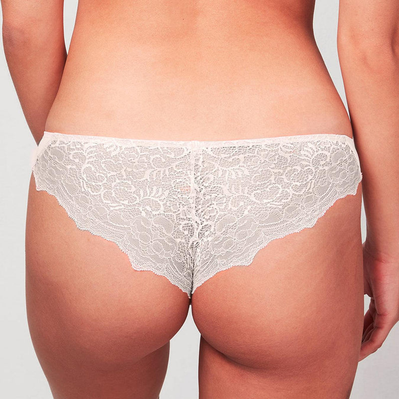Back view of model wearing a Liberté Crosby Scalloped Cheeky in blush pink featuring a sheer allover lace with scalloped edges.
