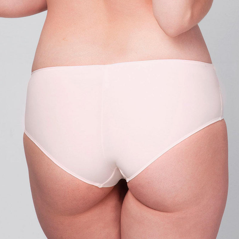 Back view of model wearing a Liberté Mid Rise Hipster in blush pink featuringCrosby performance micro jersey and lace insets.