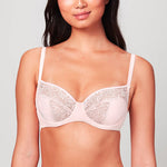 Model wearing a Blush pink Liberté Crosby Demi Bra with a 3 piece cup featuring Crosby performance micro jersey on the outside of the cup and lace on the inner cup as well as at the neckline.
