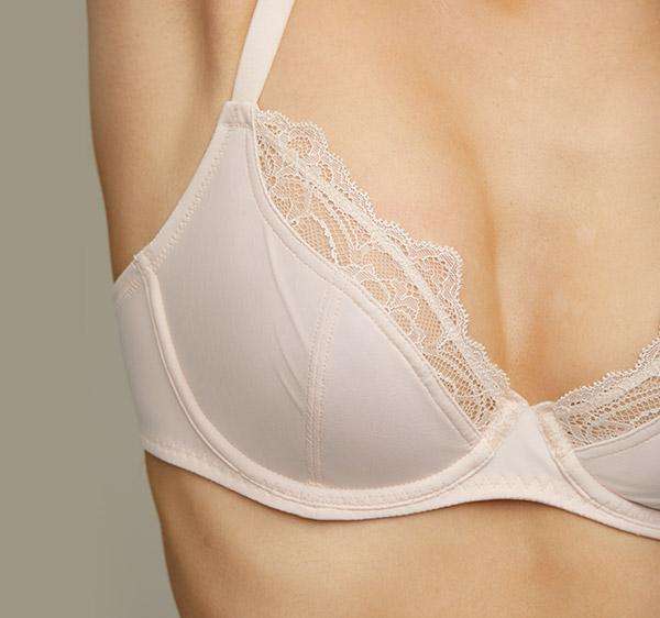 Model wearing a blush pink Liberté Crosby Plunge Bra with Crosby performance micro jersey on the bottom cup and lace with scalloped edges on the top cup.